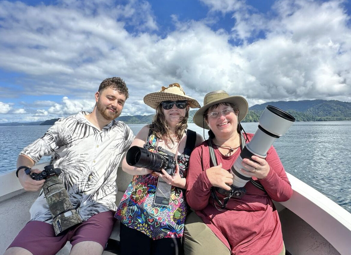 Three guests with their cameras on a boat trip